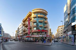 a tall building on a busy city street at Tanha Hotel in Dubai