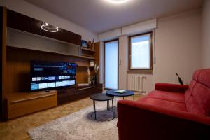 a living room with a red couch and a flat screen tv at 203 Aosta Apartment in Aosta