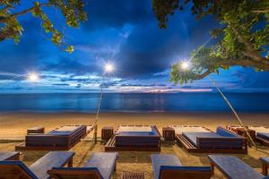 eine Gruppe von Betten am Strand in der Nacht in der Unterkunft Lanta Sand Resort & Spa in Ko Lanta