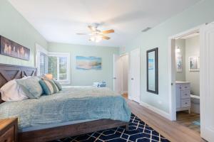a bedroom with a bed and a ceiling fan at The Redington Beach House in St. Pete Beach