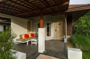 a porch of a house with a couch and a table at Lanta Sand Resort & Spa in Ko Lanta