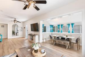 a living room with a ceiling fan and a table at The Redington Beach House in St. Pete Beach