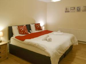 a bedroom with a large bed with red and white pillows at Rose Cottage - Uk3283 in Guyzance