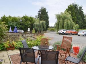 a patio with a table and chairs and parked cars at Rose Cottage - Uk3283 in Guyzance