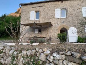 a stone house with a stone wall in front of it at Magnifique Mas Cevenol in Anduze