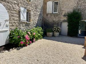 a building with a door and flowers next to a building at Magnifique Mas Cevenol in Anduze