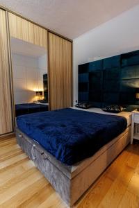 1 dormitorio con 1 cama grande y edredón azul en King Piastów & SPA, en Szczecin
