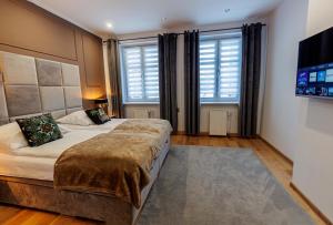 a bedroom with two beds and a flat screen tv at King Piastów & SPA in Szczecin