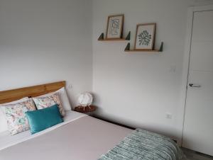 a bedroom with a bed and two pictures on the wall at Apartamento Ría de Vigo in Pontevedra