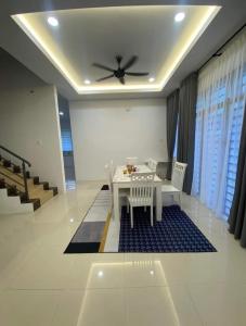 uma sala de jantar com uma mesa e uma ventoinha de tecto em Wan D'Zahra Homestay em Jitra