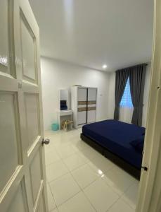 een slaapkamer met een blauw bed en een raam bij Wan D'Zahra Homestay in Jitra