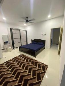 een slaapkamer met een bed en een plafondventilator bij Wan D'Zahra Homestay in Jitra