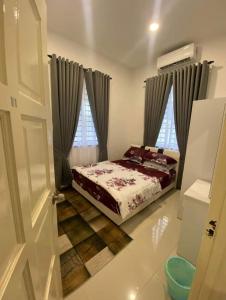 um quarto com uma cama e uma janela em Wan D'Zahra Homestay em Jitra