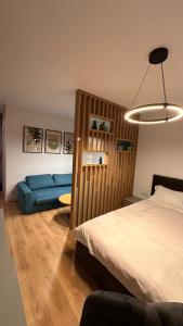 - une chambre avec un lit et un canapé bleu dans l'établissement MEB Apartments - Park Lake, à Cluj-Napoca