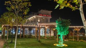 un edificio con un albero verde di fronte di İpek Palas Otel a Şanlıurfa