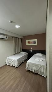 Habitación con 2 camas en una habitación en Ônix Inn Hotel Cravinhos, en Cravinhos