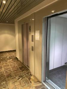 un pasillo con una puerta de cristal en un edificio en Appartement 3 salles de bains 3 chambres 6 personnes en Limoges