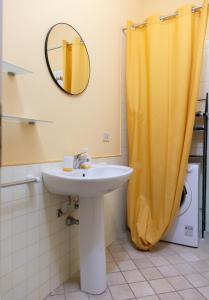 a bathroom with a sink and a yellow shower curtain at Dimora Artale in Cattedrale in Palermo +42 photos