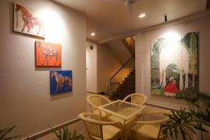 una habitación con pinturas en la pared y sillas en Labels Hotel, en Nagpur
