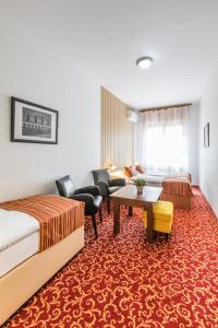 a hotel room with a bed and a living room at Hotel U Zlatého kohouta in Kroměříž
