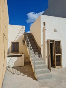 a staircase leading up to a white building with a door at EEM student Guest House (shared rooms) in Is-Swieqi