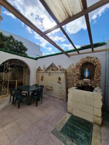 an outdoor patio with a table and a fireplace at EEM student Guest House (shared rooms) in Is-Swieqi