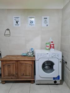 cocina con lavadora y encimera de madera en EEM student Guest House (shared rooms), en Is-Swieqi