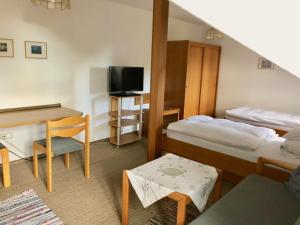 a small room with two beds and a desk at Pension Margaretenhof in Bayerbach