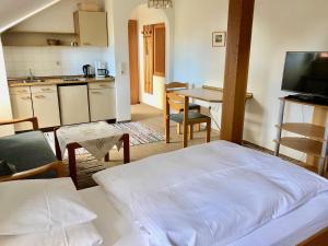 a room with a bed and a kitchen with a table at Pension Margaretenhof in Bayerbach