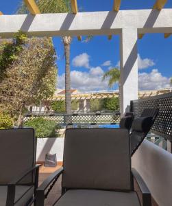 2 sillas en un balcón con vistas a la piscina en Cielo Azul, en Campoamor