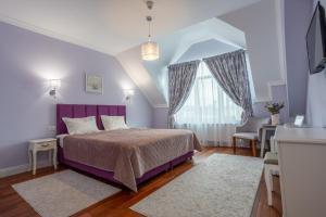um quarto com uma cama roxa e uma janela em Vila Missy em Deva