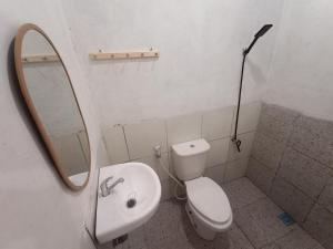 a bathroom with a toilet and a sink and a mirror at Sea La Vie in Pangandaran