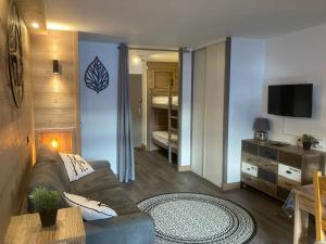 a living room with a couch and a bed at Appartement Brides Confort in Brides-les-Bains