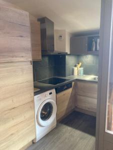 a small kitchen with a washing machine in it at Appartement Brides Confort in Brides-les-Bains