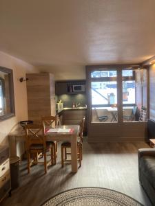 a kitchen and living room with a table and chairs at Appartement Brides Confort in Brides-les-Bains