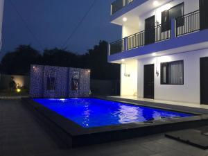 a swimming pool in front of a house at night at Danja House and Kost in Jimbaran