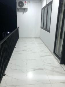 a hallway with a white tile floor in a building at Danja House and Kost in Jimbaran
