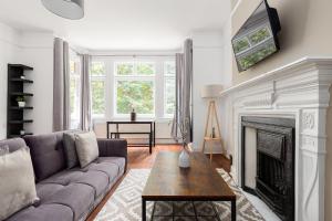 a living room with a couch and a fireplace at The Chiswick Apartments in London