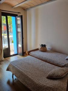 - une chambre avec 2 lits et une grande fenêtre dans l'établissement El Niu Dels Ocells, à Sant Joan de les Abadesses