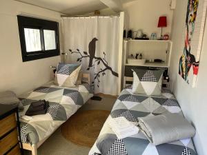 1 dormitorio con 2 camas en una habitación con ventana en Villa les 3 lumières 8-10 personnes, Clim, piscine à proximité des plages en La Ciotat