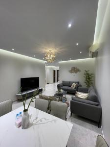 a living room with a couch and a television at شقة غرفتين وصالة مدخل خاص باركنج سيارة in Riyadh Al Khabra