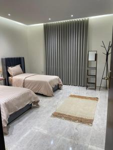 a bedroom with two beds and a rug at شقة غرفتين وصالة مدخل خاص باركنج سيارة in Riyadh Al Khabra