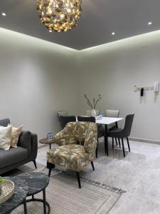 a living room with a table and a chair at شقة غرفتين وصالة مدخل خاص باركنج سيارة in Riyadh Al Khabra