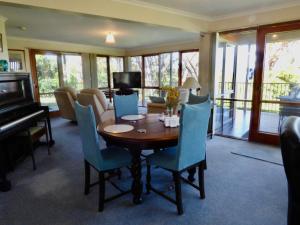a living room with a table and a piano at Bluff House in Saint Leonards +23 photos