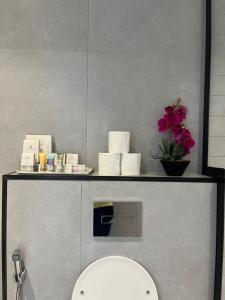 a shelf above a toilet in a bathroom at شقة فندقية رائعة - موقع مميز حطين الرياض in Riyadh