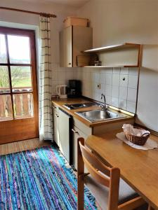 a kitchen with a sink and a wooden table at Pension Margaretenhof in Bayerbach