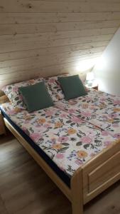ein Bett mit einer Blumendecke und 2 Kissen in der Unterkunft Agroturystyka Cieślarówka in Lubawka
