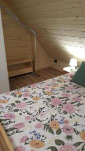 Bett mit Blumendecke in einem Zimmer in der Unterkunft Agroturystyka Cieślarówka in Lubawka