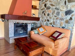 a living room with a couch and a stone fireplace at La casita de Cerler in Cerler
