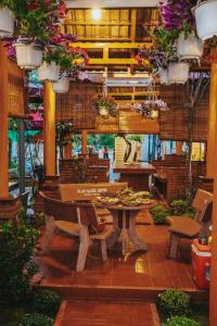 a patio with a table and chairs and flowers at VILLA GIÓ BIỂN LAGI - Villa Gia đình 4 Phòng Ngủ, Sức chứa 8 - 20 Khách, Cách Biển Cam Bình 700m di chuyển, Sân Vườn Rộng Rãi, Tiện Nghi Nướng BBQ & Bãi Đậu Xe Ô tô Miễn Phí in La Gi